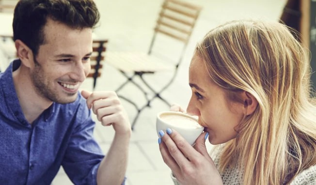 woman drinks coffee with man