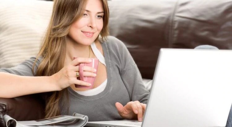 woman with laptop drink something